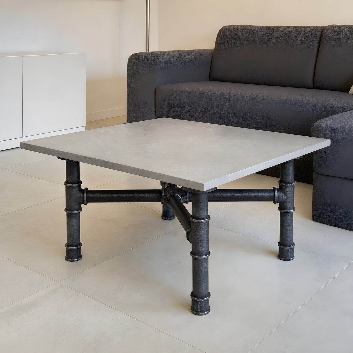 Base per tavolino, ghisa e acciaio verniciato, a croce Ø 42 mm, in ambiente sotto un piano in cemento chiaro levigato