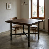 Base per tavolo da pranzo, ghisa e acciaio verniciato, a croce Ø 42 mm, in ambiente sotto un piano spesso in rovere affumicato